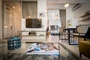 a living room with a television and a table and chairs at VELLER Rienes in Tel Aviv