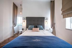 a bedroom with a large bed and two windows at VELLER Rienes in Tel Aviv