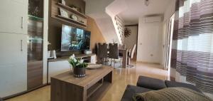 Beautiful duplex with jacuzzi في بورتو ريكو: غرفة معيشة مع أريكة وتلفزيون