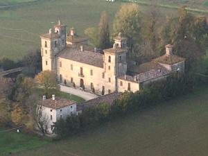 a large castle in the middle of a field at Ostello Castello Mina Della Scala in Casteldidone
