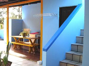 una casa azul con una mesa y una pared azul en Pousada Serafin Azul, en Florianópolis