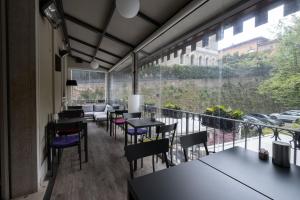 un ristorante con tavoli e sedie e un balcone di Fuori Porta House a Bergamo