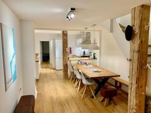 a kitchen and dining room with a wooden table and chairs at Fischerhaus von 1680 Travemünde in Lübeck