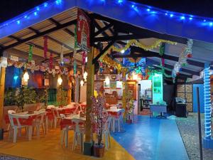 a restaurant with tables and chairs and lights at Moalboal Bamboo Guest House in Moalboal
