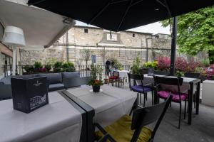 un patio con tavoli, sedie e ombrellone di Fuori Porta House a Bergamo