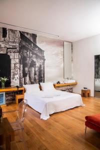 a bedroom with a large white bed and a tv at Aire Hotel & Ancient Baths in Almería +82 photos
