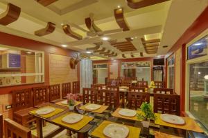 a dining room with wooden tables and chairs at LEISURE VALLEY BEACH RESORT in Varkala