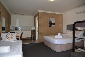 a room with a bed, a table, and a television at Albury Allawa Motor Inn in Albury