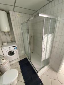 a bathroom with a shower and a washing machine at Apartamento Atlantico - Vista Mar in Monte Gordo