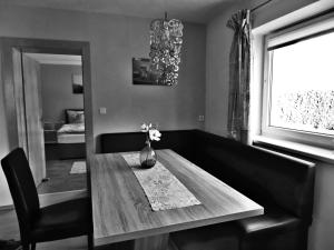 een eettafel met een vaas met bloemen erop bij Appartement Reiter in Aschau