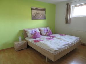 een slaapkamer met een bed met roze kussens en een raam bij Appartement Reiter in Aschau