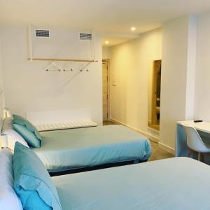 um quarto com duas camas e um lavatório em Hotel Gran Sol De Extremadura em Montijo