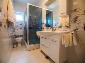 a bathroom with a shower and a sink and a toilet at Apartments Anita 1 in Barbat na Rabu +93 photos