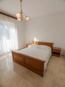 a bedroom with a large bed with white sheets at Apartments Anita 1 in Barbat na Rabu
