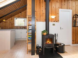 a kitchen with a stove in a room with wooden walls at 6 person holiday home in Fårvang in Fårvang