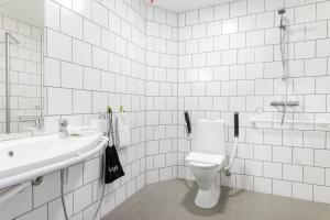 a white bathroom with a toilet and a sink at GreenStar Hotel Vaasa in Vaasa +17 photos