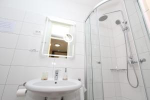 a white bathroom with a sink and a shower at Room Roma in Rovinj