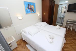 a hotel room with a white bed and a mirror at Room Roma in Rovinj