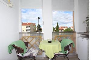 a small table and chairs on a balcony with a window at Room Roma in Rovinj