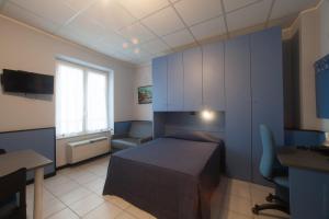 a bedroom with a bed and a desk and a window at Hotel Tirreno in Genoa