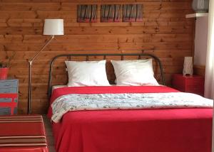 a bedroom with a red bed with a wooden wall at Le Studio Rouge de la Gare in Vieux-Boucau-les-Bains