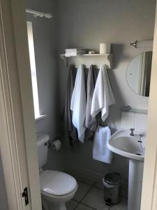 a bathroom with a toilet and a sink with towels at Venetia House - small guesthouse in Galway