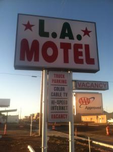 una señal para un motel con varias señales en LA Motel, en Claude