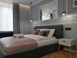 a bedroom with a large bed with pink pillows at Apartament LUCY - ścisłe centrum Częstochowy in Częstochowa