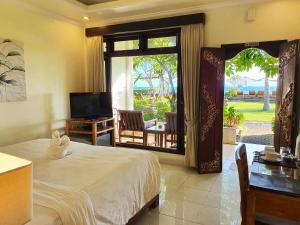 a bedroom with a bed and a sliding glass door at Hotel Genggong in Candidasa
