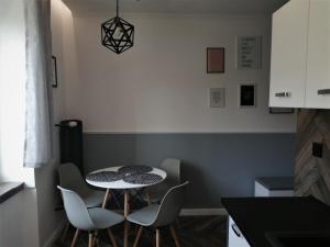 a small kitchen with a table and chairs at Apartament LUCY - ścisłe centrum Częstochowy in Częstochowa
