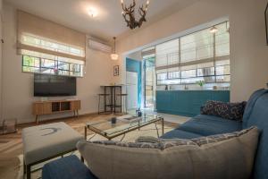 uma sala de estar com um sofá e uma televisão em VELLER Ben Yehuda em Tel Aviv