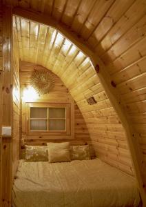 a bedroom with a bed in a wooden room at The Gold Pod, relax and enjoy on a Glamping house in Corredoura