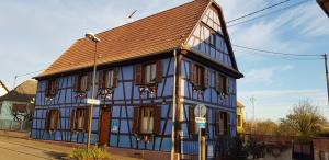 un edificio azul y blanco con techo marrón en maisonbleue67 en Kurtzenhouse
