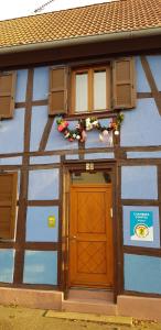 un edificio azul con puerta y ventanas de madera en maisonbleue67 en Kurtzenhouse