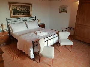 a bedroom with a large bed and two chairs at La Torre in Chianti in Siena