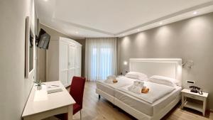 a bedroom with a bed with two teddy bears on it at Hotel Terme Leonardo in Abano Terme