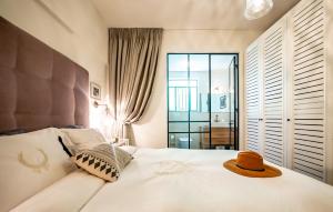 a bedroom with a bed with a hat on it at VELLER Olifant in Tel Aviv