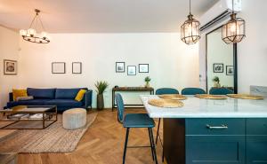 a living room with a blue couch and a table at VELLER Olifant in Tel Aviv