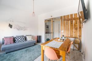 Graça Charming Apartment في لشبونة: غرفة معيشة مع طاولة وأريكة