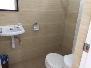 a bathroom with a toilet and a sink at Heartland Hotel Serviced Rooms & Apartments. in Panglao