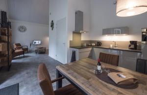 a dining table with a bottle of wine on it in a kitchen at Veul oe thuus Hoeve Kroep an in Vorden