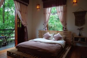 a bedroom with a bed and a large window at Sum Villa Homestay Mang Den in Kon Von Kla