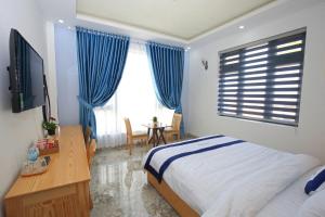 a bedroom with a bed and a desk and a television at Luan'S Villa in Da Lat