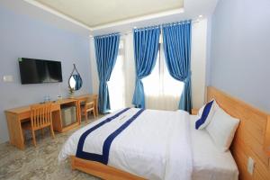 a bedroom with a bed and a desk and a television at Luan'S Villa in Da Lat