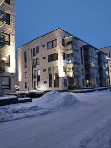 a large building with snow in front of it at Aurora Haven Rovaniemi Modern DT Apartment -Self Check-In & Free Wifi- in Rovaniemi