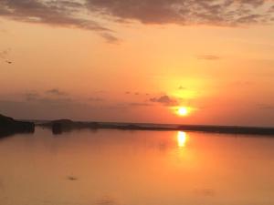 una puesta de sol sobre un cuerpo de agua con la puesta de sol en The Lord's Prayer en Chennai