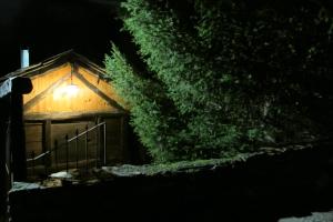 a cabin with a light on the side of it at night at Casa Turismo Rural O FILANDÓN in Suertes