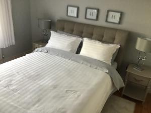 una camera da letto con un grande letto con lenzuola e cuscini bianchi di Venetia House - small guesthouse a Galway