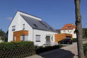 a white house with a black roof and a car at Stilvolles Studio in Osnabrück