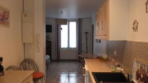 a kitchen with a table and chairs in a room at Le Jardinet in Pont-Sainte-Maxence +10 photos